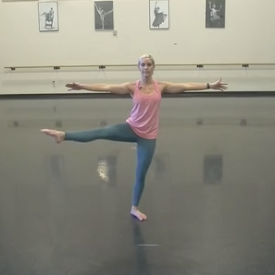 Alicia stands with one foot out to the side and both arms extended