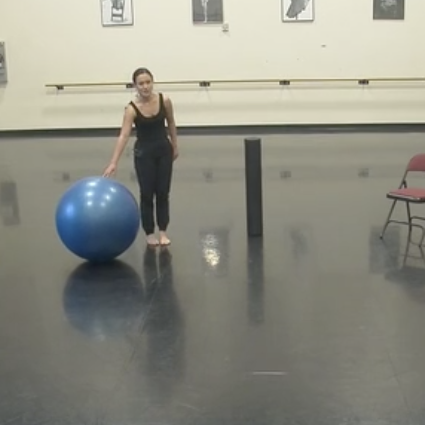 Jessica stands with a blue exercise ball and a foam roller